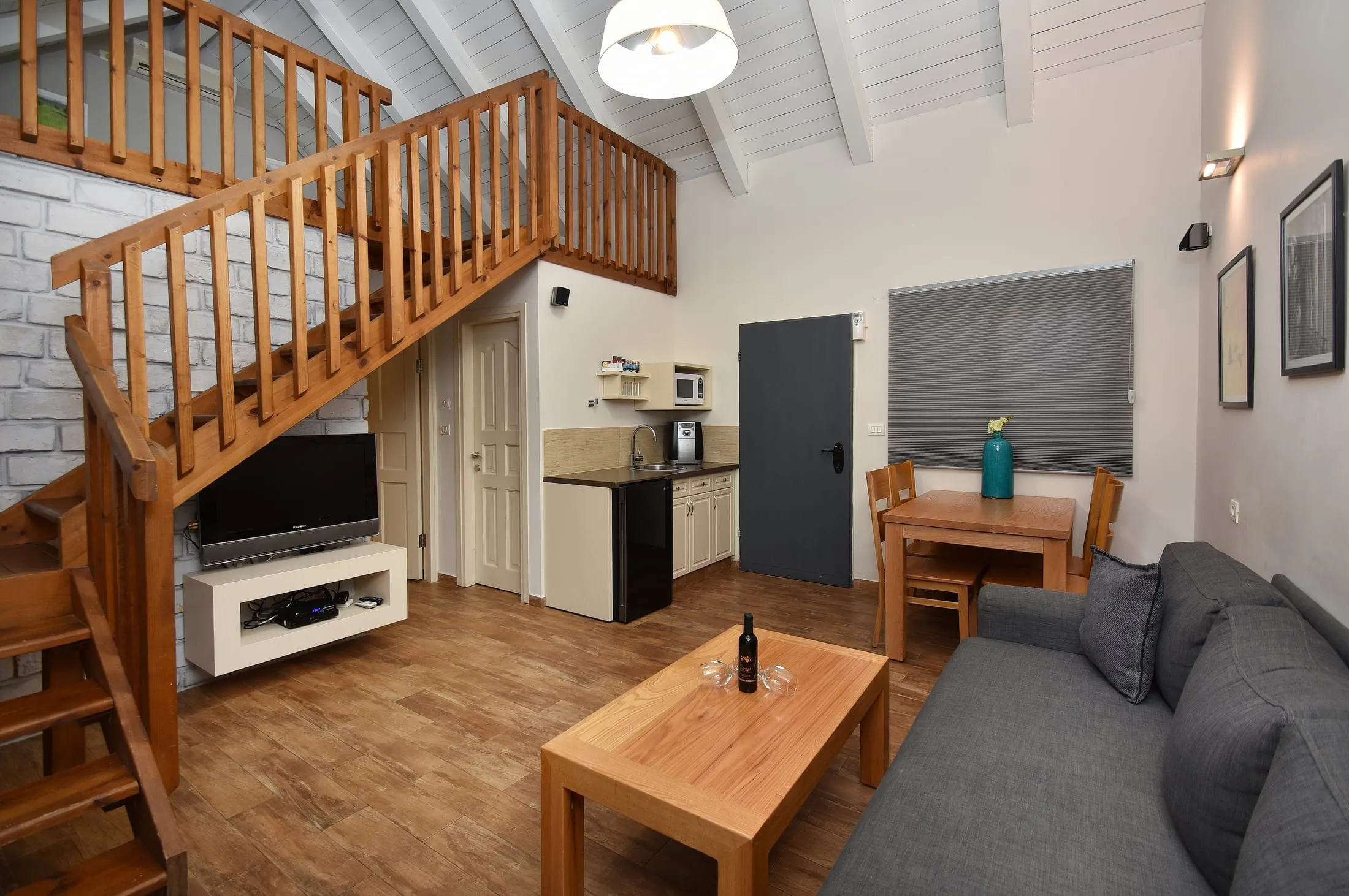Duplex family suite living room with kitchenette and stairs to gallery sleeping loft
