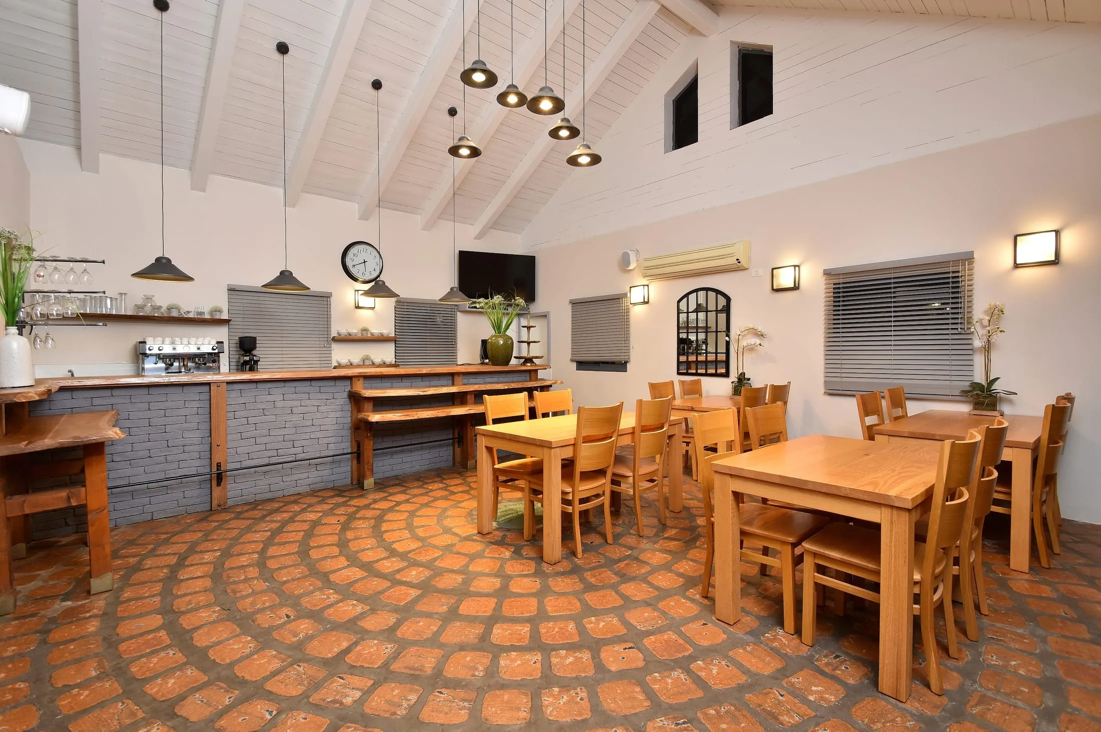 Bright dining room with vaulted ceiling, wooden tables and coffee counter for the resort breakfast